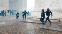 Des policiers en action face à des manifestants "Gilets Jaunes", au pied de l'Arc de Triomphe