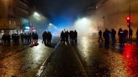 Des policiers en tenue anti-émeute font face à des manifestants dans une rue parisienne